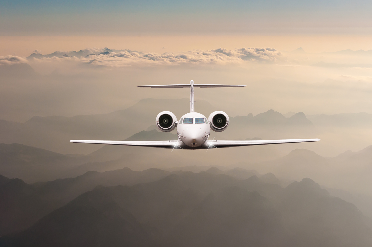 Airplane fly over clouds and Alps mountain on sunset. Front